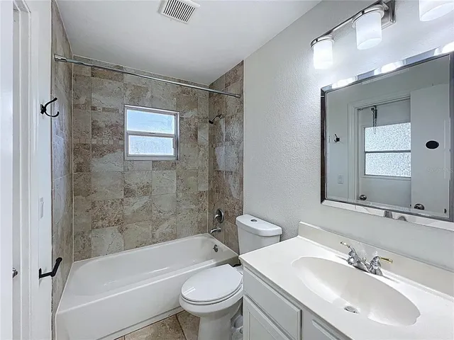 a bathroom with a sink mirror toilet and bathtub