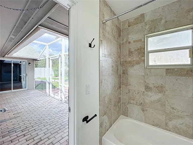 an empty room with a window and ceiling fan