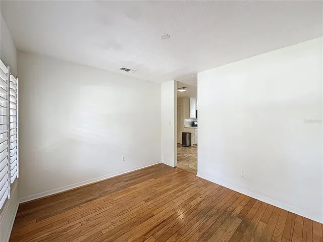 a view of empty room with wooden floor