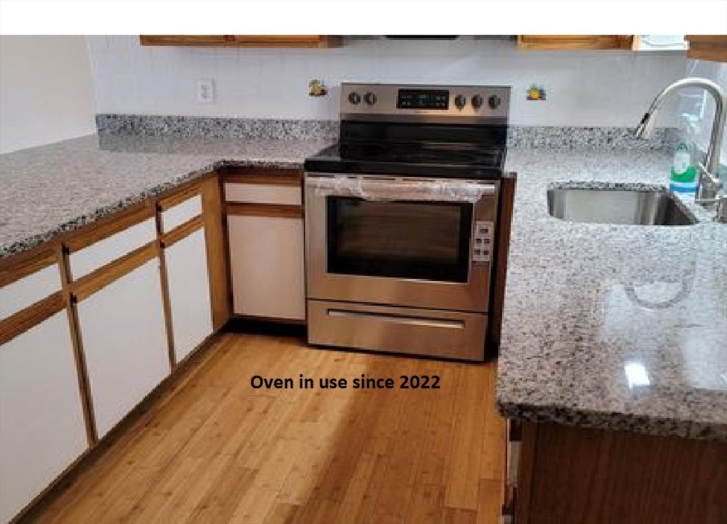360 Littleton Road, Unit G10 Chelmsford, MA 01824 - Photo 3 of 20 a kitchen with granite countertop a sink and a stove top oven