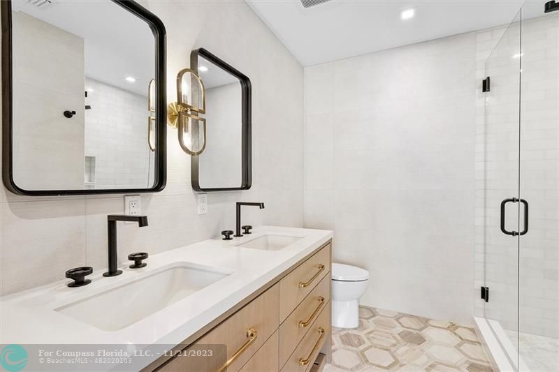 1950 Waters Edge Lauderdale-by-the-Sea, FL 33062 - Photo 12 of 38 a bathroom with a double vanity sink toilet mirror and shower