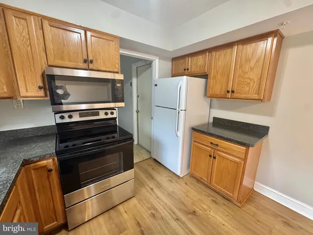 a kitchen with granite countertop a refrigerator stove and microwave