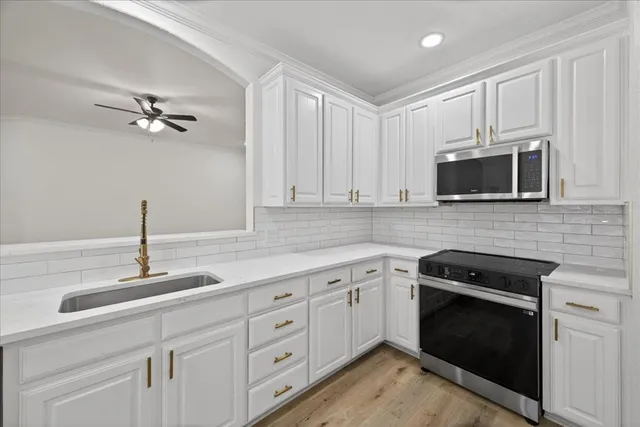 a kitchen with cabinets stainless steel appliances and a sink