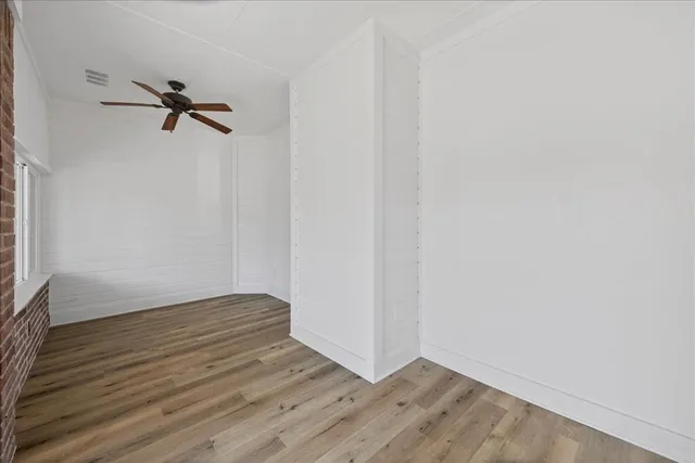 a view of a livingroom with wooden floor and a ceiling fan