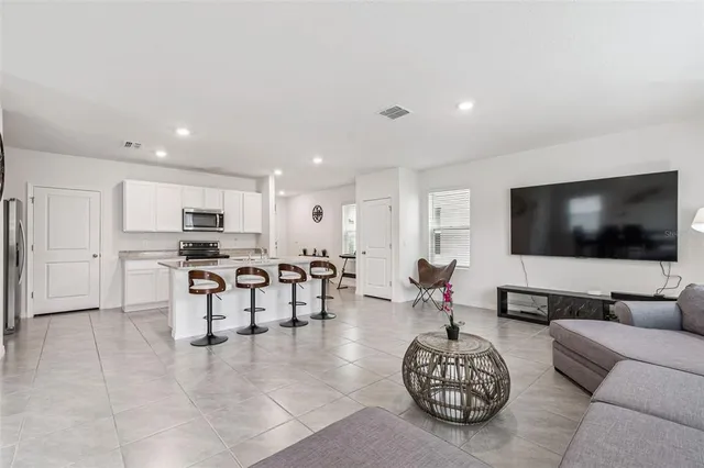 a kitchen with stainless steel appliances granite countertop a refrigerator and a stove top oven with white cabinets