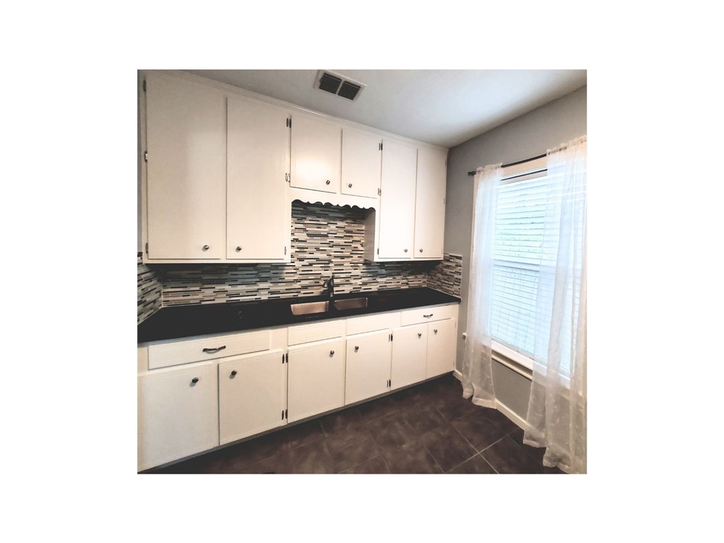 2806 Topeka Street Corpus Christi, TX 78404 - Photo 7 of 12 a kitchen with granite countertop white cabinets and white appliances