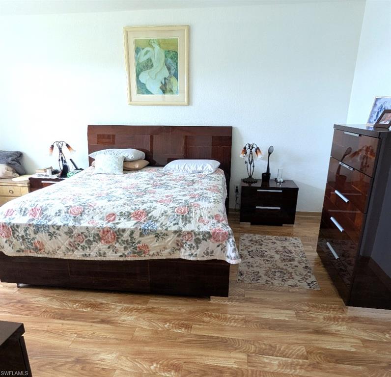 20176 Larino Loop Estero, FL 33928 - Photo 19 of 31 a bedroom with a bed and wooden floor