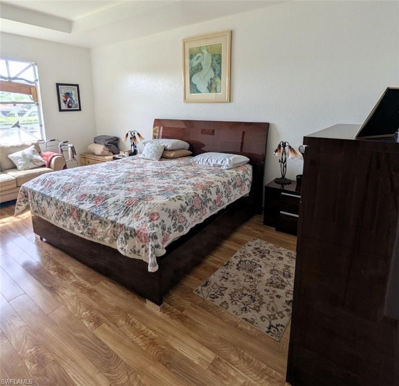 20176 Larino Loop Estero, FL 33928 - Photo 21 of 31 a bedroom with a bed and wooden floor