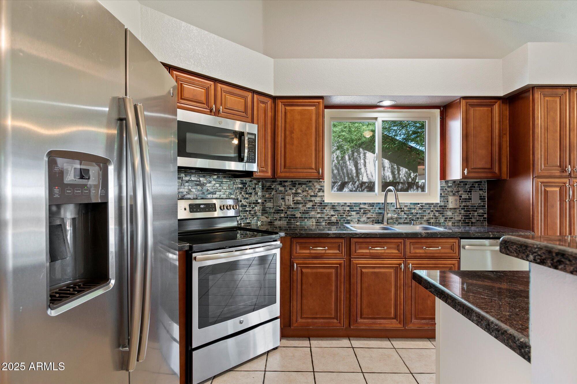 8540 West Ocotillo Road Glendale, AZ 85305 - Photo 10 of 22 a kitchen with stainless steel appliances granite countertop a stove a sink and a microwave