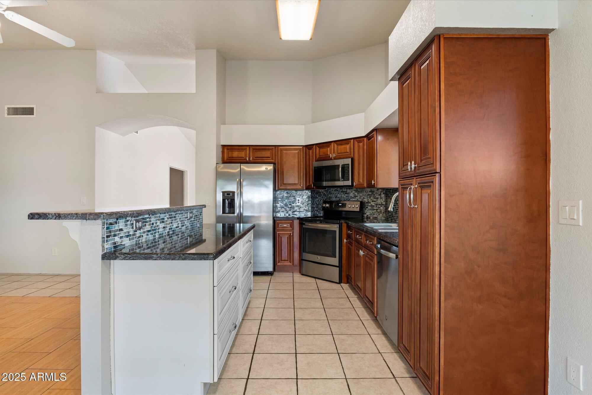 8540 West Ocotillo Road Glendale, AZ 85305 - Photo 12 of 22 a kitchen with stainless steel appliances granite countertop a refrigerator and a stove
