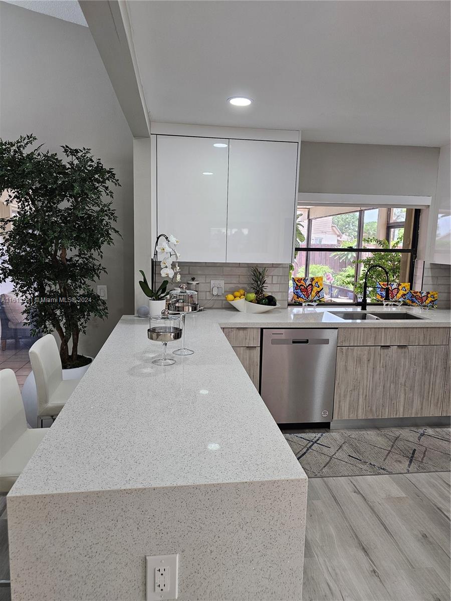 4323 Southwest 148th Place Miami, FL 33185 - Photo 19 of 70 a kitchen with a sink a stove and cabinets