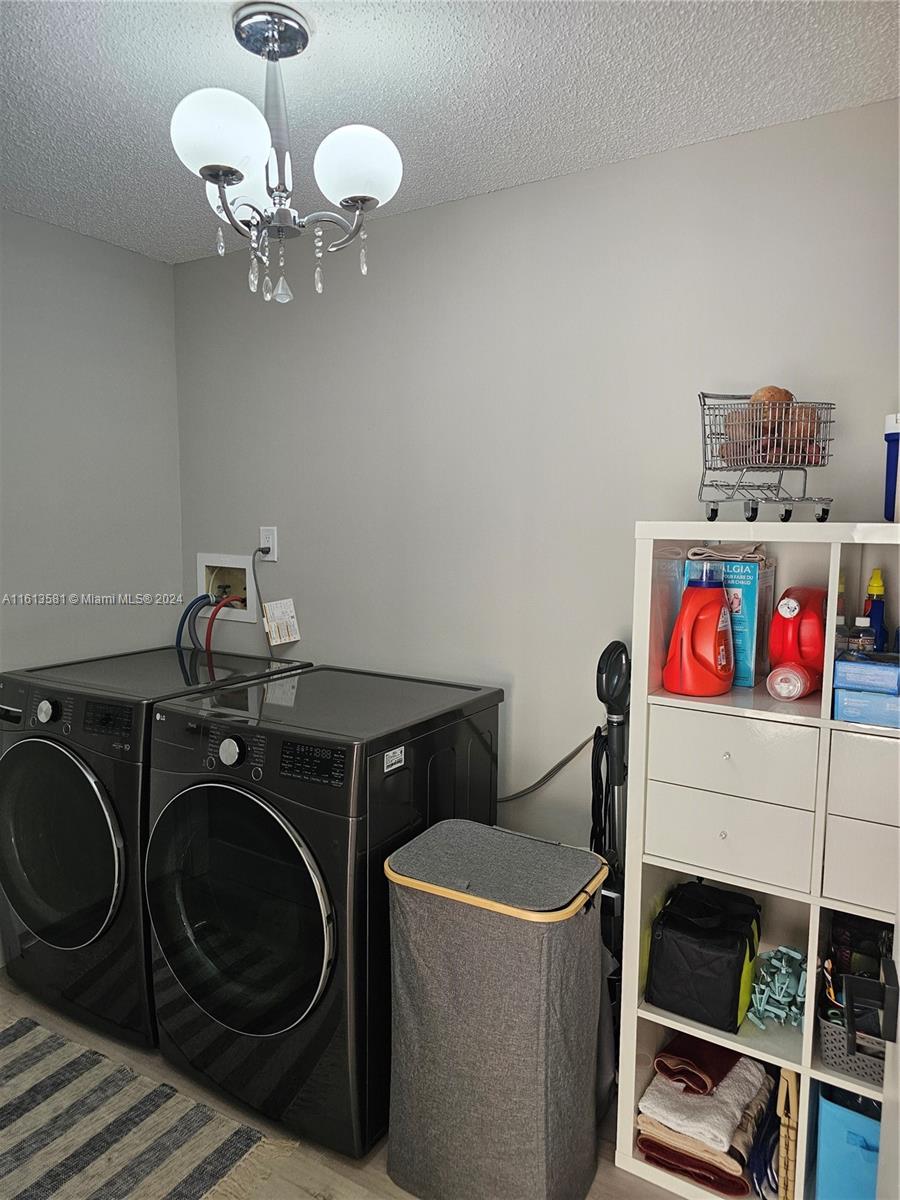 4323 Southwest 148th Place Miami, FL 33185 - Photo 22 of 70 a utility room with dryer washer and a view of kitchen