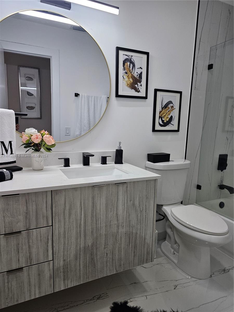 4323 Southwest 148th Place Miami, FL 33185 - Photo 39 of 70 a bathroom with a toilet a sink and mirror
