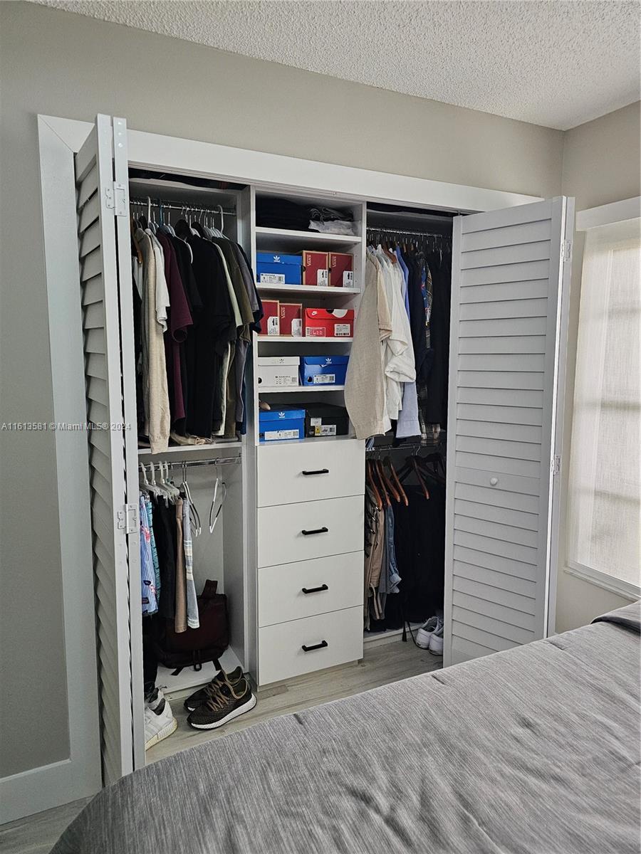 4323 Southwest 148th Place Miami, FL 33185 - Photo 43 of 70 a view of walk in closet with clothes and shoes