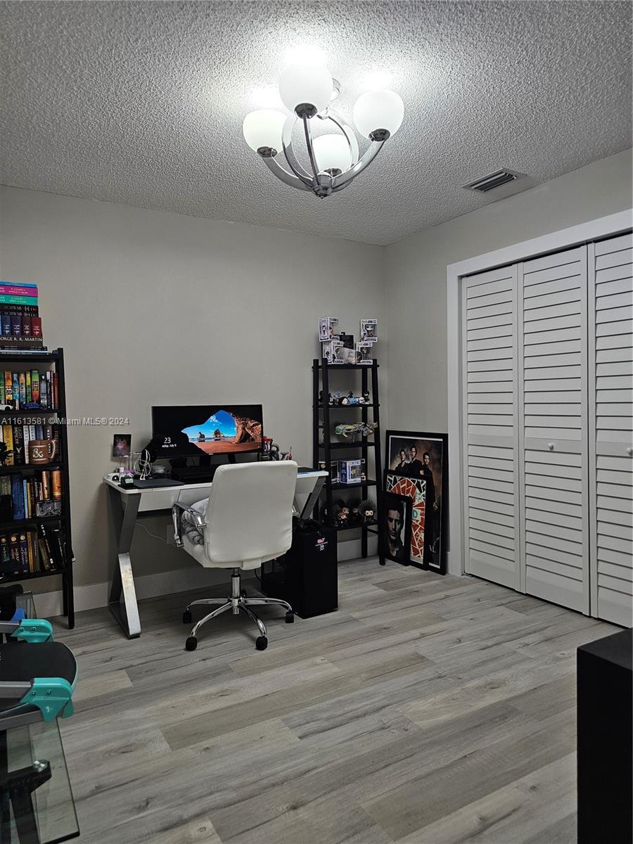 4323 Southwest 148th Place Miami, FL 33185 - Photo 45 of 70 a view of a workspace with furniture and a bookshelf