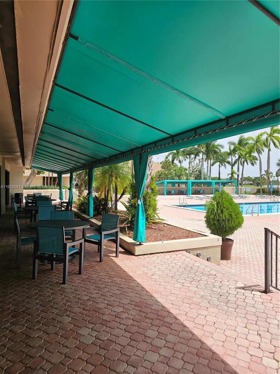 4323 Southwest 148th Place Miami, FL 33185 - Photo 58 of 70 a view of a patio with a table and chairs under an umbrella