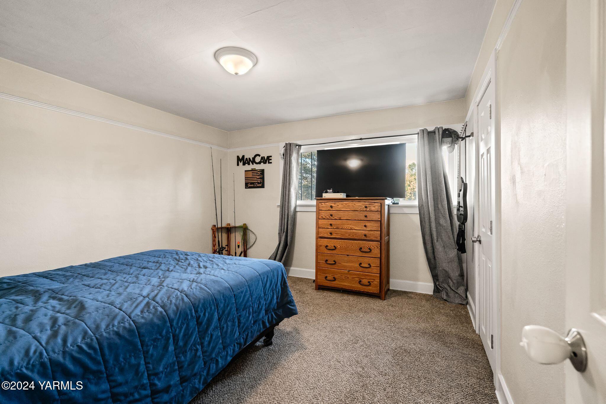 13700 Rutherford Road Yakima, WA 98903 - Photo 21 of 46 a bedroom with a bed and a flat screen tv