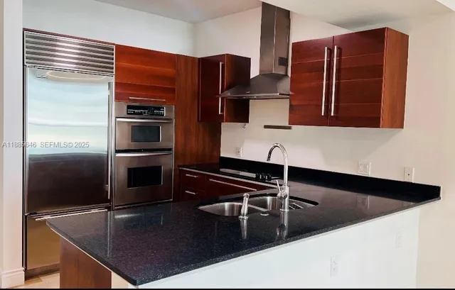 a kitchen with stainless steel appliances a sink and a refrigerator