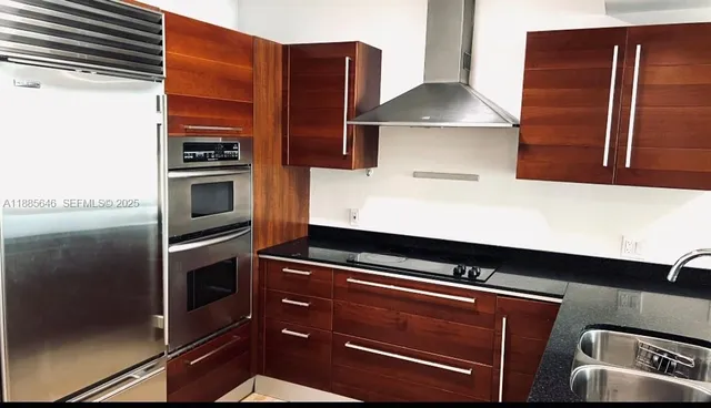 a kitchen with granite countertop stainless steel appliances and wooden cabinets