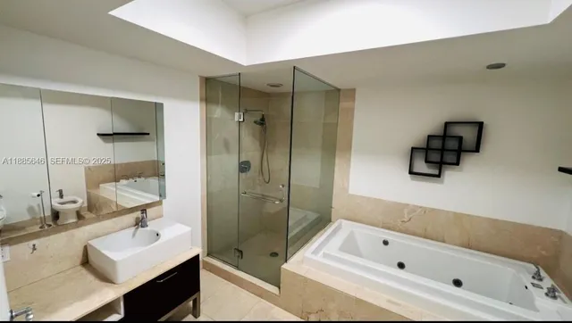 a bathroom with a tub sink a mirror and a shower