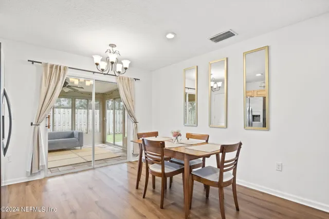 a view of a dining room with furniture wooden floor and chandelier