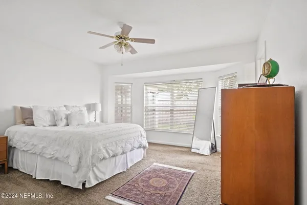 a bedroom with a bed lamps and table