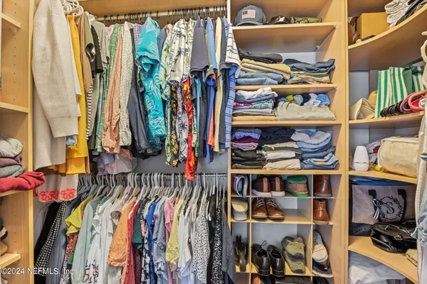 a view of walk in closet with clothes and shoes