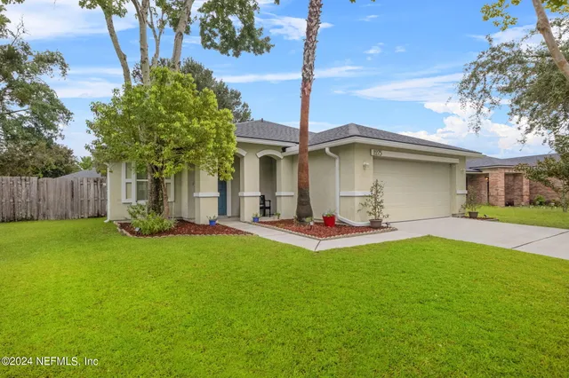 a view of a house with backyard and sitting area