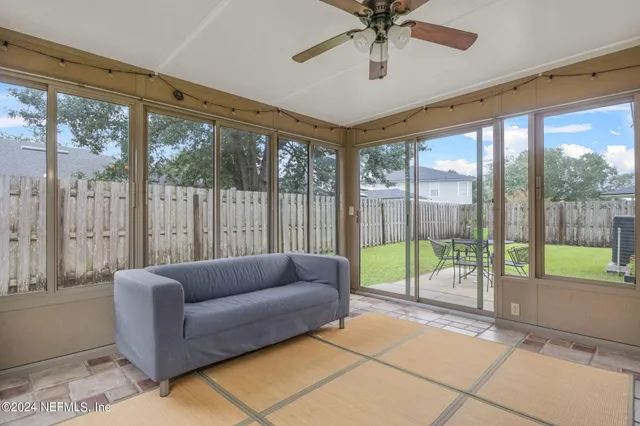 a living room with furniture and a floor to ceiling window