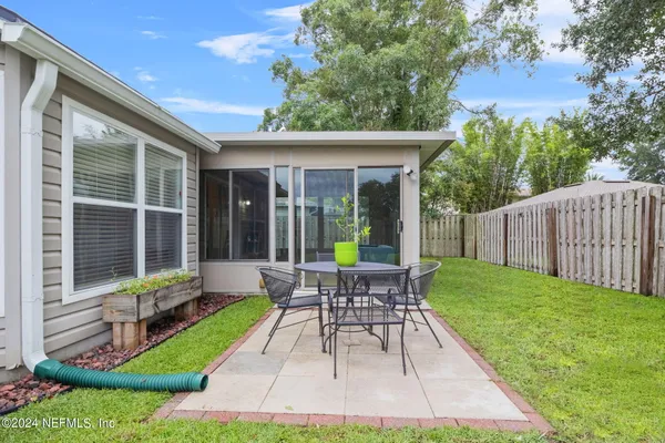 a view of a chair and table in backyard of the house