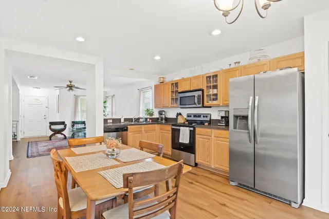 a large kitchen with a table chairs refrigerator and microwave