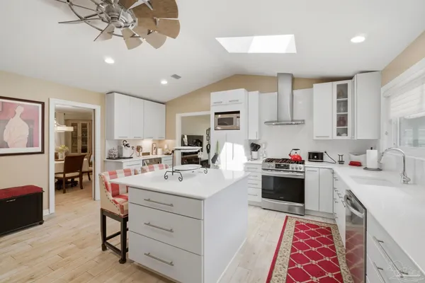 a kitchen that has a lot of cabinets a sink and appliances