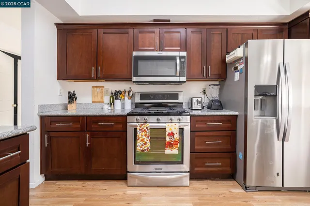 a kitchen with granite countertop a sink cabinets and wooden floor