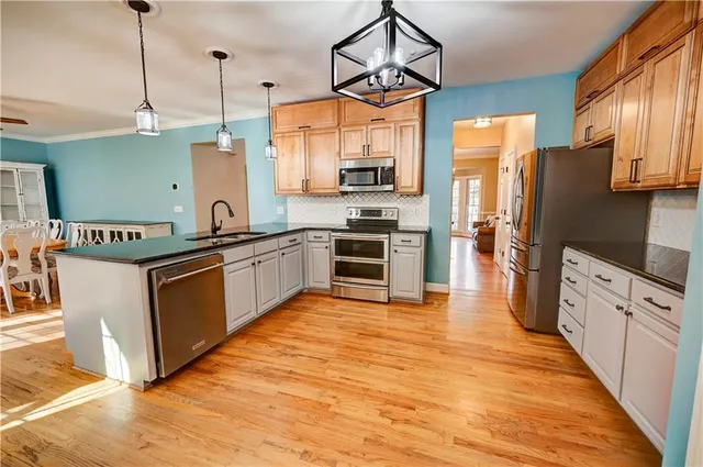 a dining room with chandelier fan and wooden floor