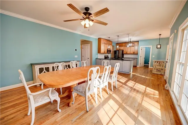 a view of a hallway with wooden floor and a bathroom