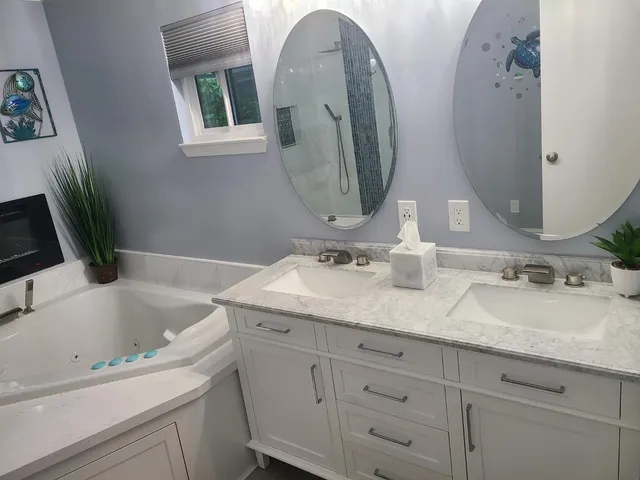 a bathroom with a tub sink and mirror