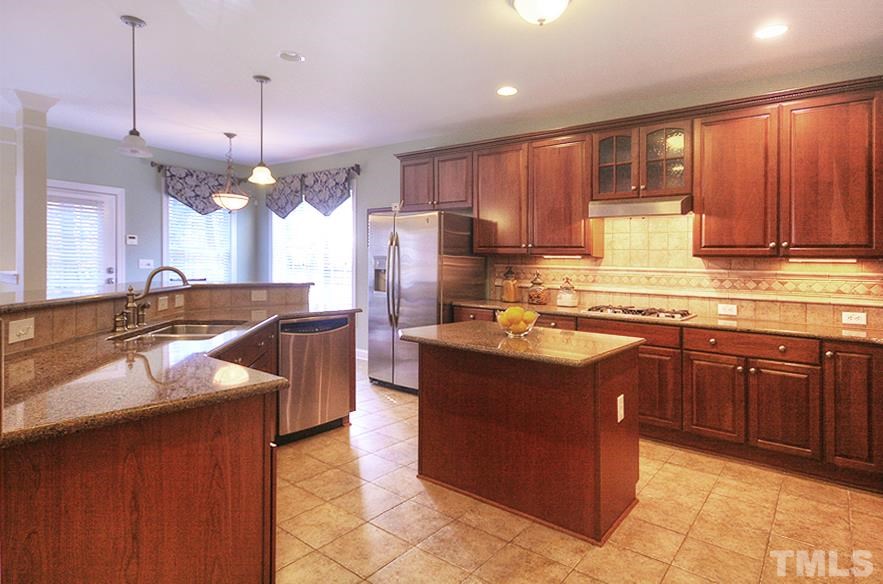 10008 Darling Street Raleigh, NC 27613 - Photo 7 of 24 a kitchen with kitchen island granite countertop a sink counter top space cabinets and stainless steel appliances
