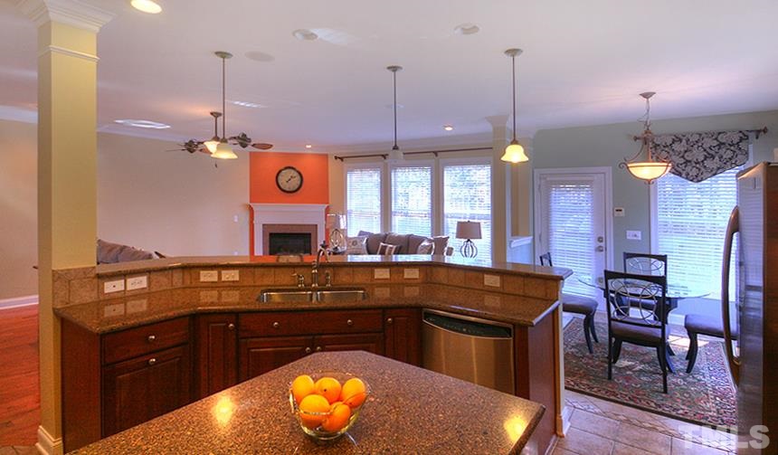 10008 Darling Street Raleigh, NC 27613 - Photo 8 of 24 a kitchen with a wooden floor and a view of living room