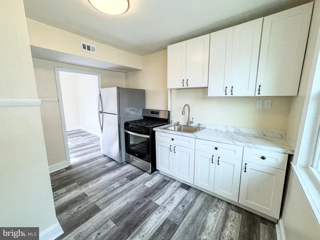 a kitchen with granite countertop white cabinets and white appliances