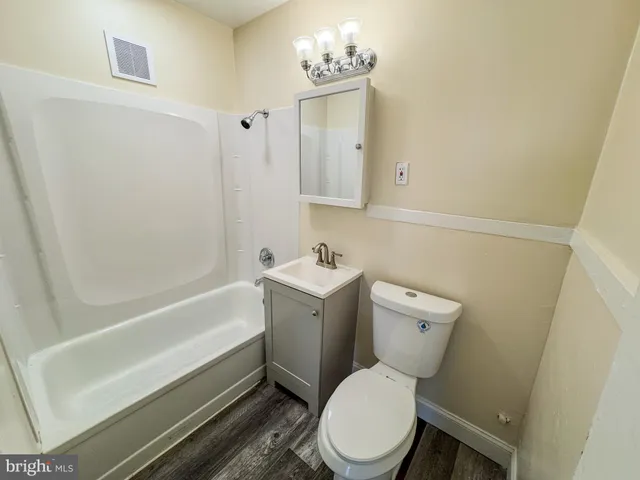 a white toilet sitting next to a bath tub