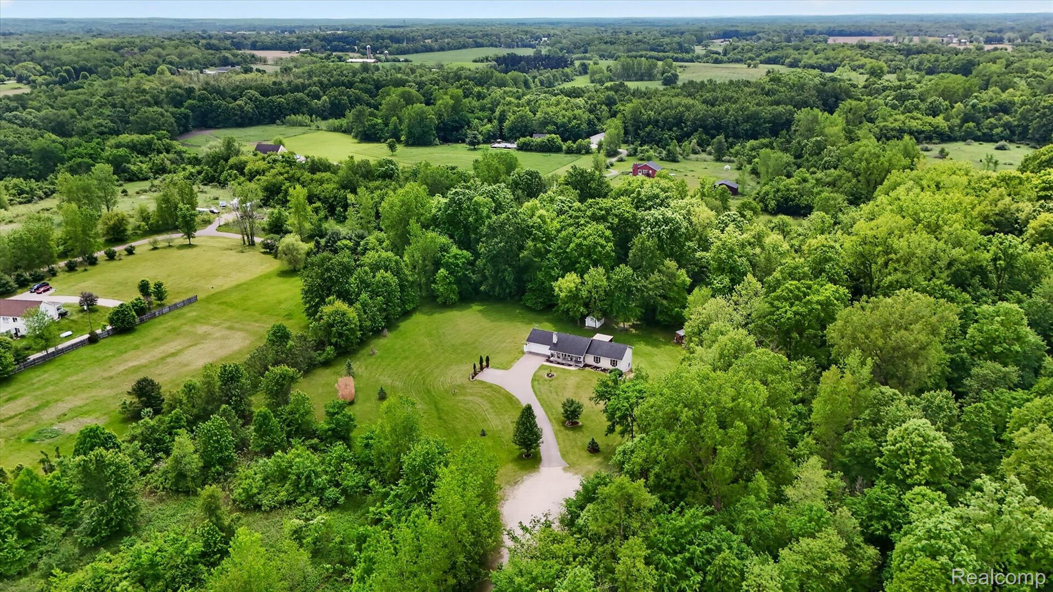 9565 Crofoot Road Fowlerville, MI 48836 - Photo 53 of 63 Sprawling acreage featuring a single-story residence, extensive green lawns, mature trees, and a winding driveway