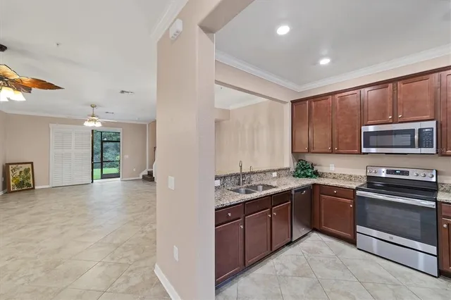 a kitchen with stainless steel appliances granite countertop a stove a sink and a refrigerator