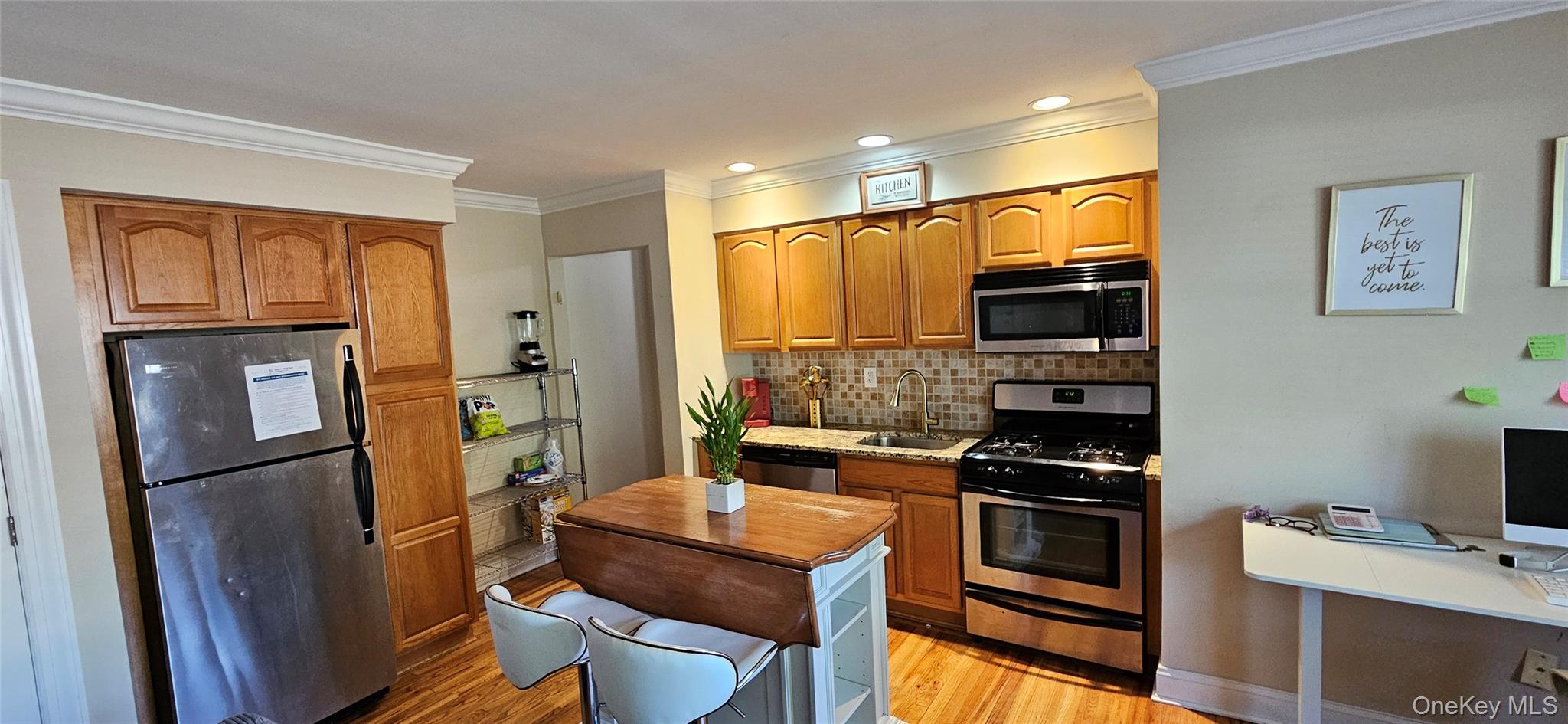237 North Middletown Road, Unit H Pearl River, NY 10965 - Photo 5 of 14 Kitchen with stainless steel appliances, light wood finished floors, ornamental molding, decorative backsplash, and brown cabinets