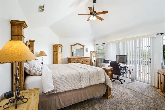 a bedroom with a bed a chandelier and dresser