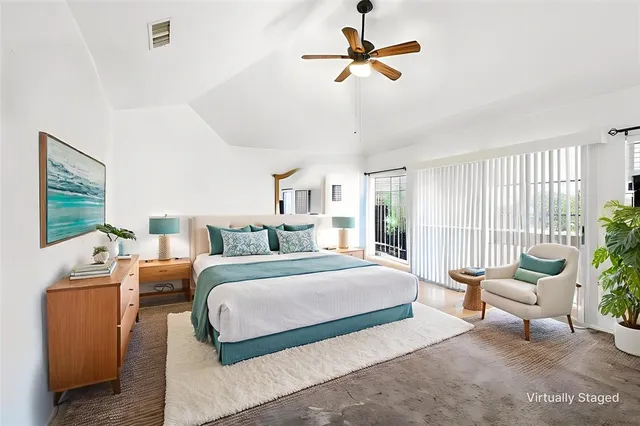 a spacious bedroom with a bed a couch and a window