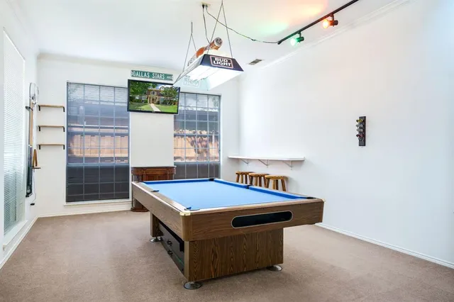 a room with pool table and windows
