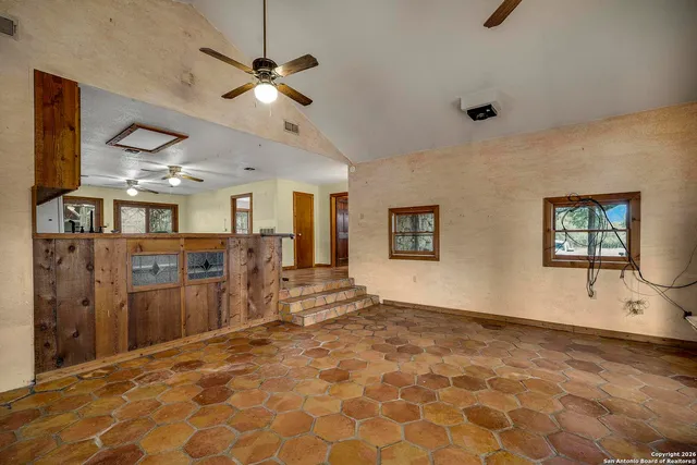 a view of a livingroom with a furniture ceiling fan and window