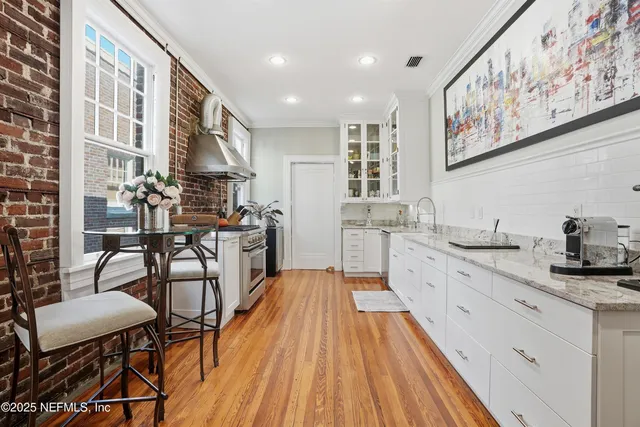 a kitchen with a stove and wooden floor