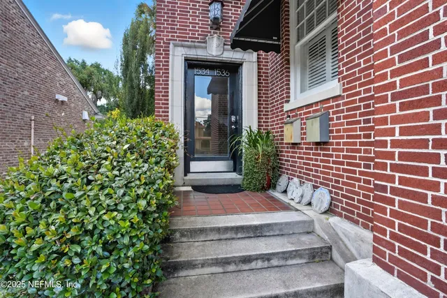 a view of house with a yard and plants
