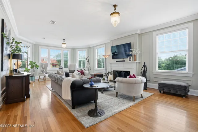 a view of a hallway with wooden floor and furniture